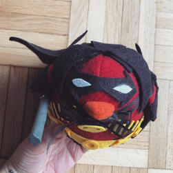A plushie bird of Tim Drake in his Red Robin costume